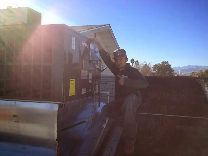 HVAC technician performing Boiler Repair on a rooftop unit in East Niles